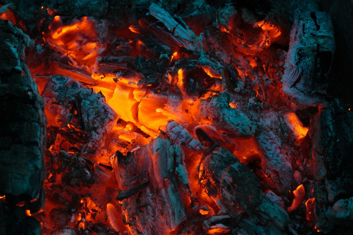 Braises incandescentes rougeoyantes au cœur d'un foyer