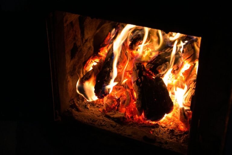 Gros plan de flammes vives et de bûches qui brûlent dans un foyer